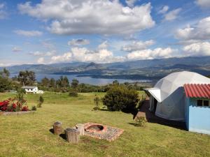 ein weißes Zelt auf einem Feld mit einer Feuerstelle in der Unterkunft Glamping hermoso amanecer in Guatavita