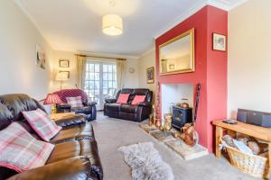 a living room with a couch and a fire place at Ivy Cottage in Helmsley