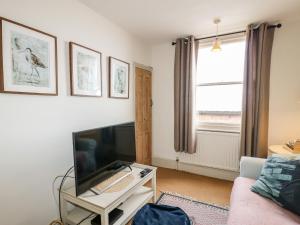 a living room with a large tv and a couch at Church House in Matlock