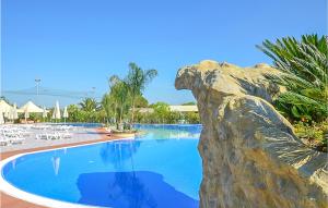 una piscina in un resort con una statua di dinosauro di Alessidamo Bilo a Metaponto