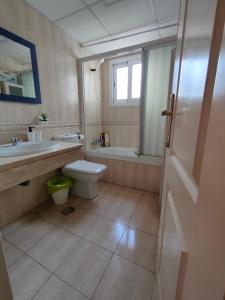 een badkamer met een toilet, een wastafel en een bad bij Penthouse Near The Beach in Fuengirola