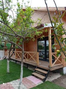 una casa pequeña con porche y terraza en Denizimapartbungalov, en Demre