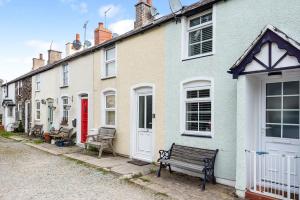 une rangée de maisons avec un banc dans une rue dans l'établissement Fishermans Cottage, à Conwy