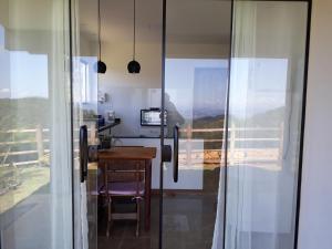 ein Zimmer mit einem Schreibtisch und einem Tisch mit einem Fenster in der Unterkunft Chalé Privilégio in Rio Prêto