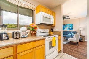 een keuken met een fornuis en een magnetron bij Kahana Manor 418 condo in Kahana