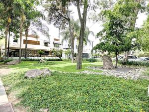 a park with rocks and trees and a building at Hotel CLARUM 101 in Guadalajara