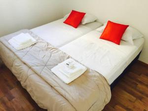 2 camas con almohadas rojas y blancas en una habitación en Alojamiento Centrico Bahia Blanca en Bahía Blanca