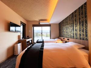 a hotel room with two beds and a tv at Rinn Gion Kenninji in Kyoto