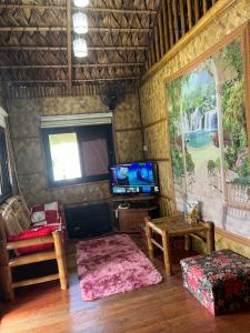 a living room with a large painting on the wall at Bahay Kubo ZaiLaiH in Silang