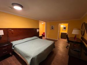 a hotel room with a bed and a desk at Dragon INN & Suites in Fayette