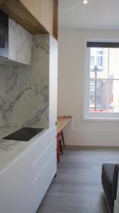 a kitchen with marble counter tops and a window at Brick Lane Base in London