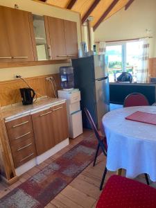eine Küche mit einem Tisch und einem Kühlschrank in der Unterkunft Ventisca Sur in Coihaique