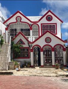 una casa roja y blanca con muchas ventanas en Samana house en Santa Bárbara de Samaná