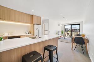 a kitchen with a counter and stools in a room at Toru Executive Apartment in Queenstown