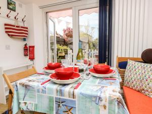 una mesa con tazones rojos y platos en ella en White Haven en Sandown