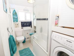 Un baño con inodoro y lavadora. en White Haven, en Sandown 27 fotos más
