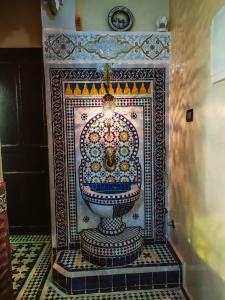 a bathroom with a decorated toilet in a room at Dar Rihanne in Fès