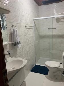a bathroom with a shower and a toilet and a sink at Recanto Benedetti, casa para temporada in Campos do Jordão