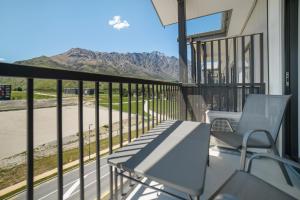 a balcony with two chairs and a view of a mountain at Toru Top Floor Apartment - Brand New & Convenient in Queenstown