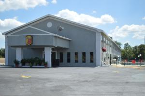 a large white building with a fast food restaurant at Super 8 by Wyndham Ardmore in Ardmore