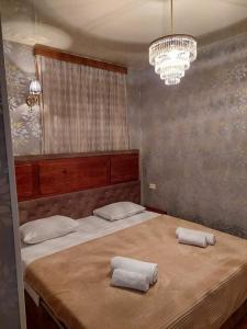 a bedroom with a large bed with two towels on it at Hotel Devino in Kutaisi