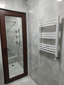 a bathroom with a glass shower with a mirror at Hotel Devino in Kutaisi