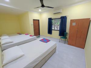 a bedroom with two beds and a ceiling fan at Evergreen Xperience Guest House in Kuala Kubu Baharu