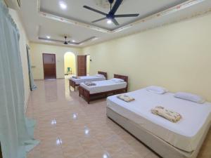 a bedroom with two beds and a living room at Evergreen Xperience Guest House in Kuala Kubu Baharu