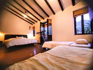 una habitación con 2 camas y una cámara. en Hostal Boutique Nariño Plaza, en Villa de Leyva