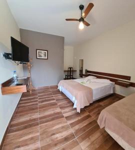 a bedroom with a bed and a flat screen tv at Estância Canaã Atibaia in Atibaia