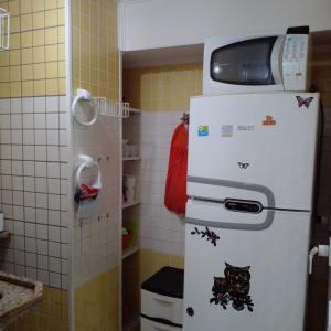 un frigorifero con forno a microonde in cima in una cucina di Praia de Pitangueiras, flat, do lado da praia sem roupas de cama a Guarujá