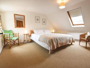 a bedroom with a bed and two chairs and a mirror at Brynawelon in Newport