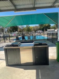 a table under a tent with a pool in the background at Bundalong Riverside Resort in Bundalong