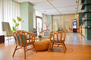 eine Lobby mit Stühlen und einem Tisch in einem Laden in der Unterkunft Louis Kienne Hotel Pemuda in Semarang