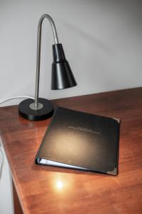 a laptop sitting on top of a desk with a lamp at The Aspen & Apartments in Sale