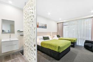 a hotel room with a bed and a bathroom at The Aspen & Apartments in Sale