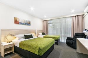 une chambre d'hôtel avec un lit et un canapé dans l'établissement The Aspen & Apartments, à Sale