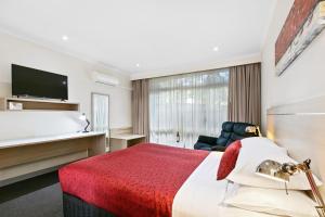 een hotelkamer met een bed en een televisie bij The Aspen & Apartments in Sale
