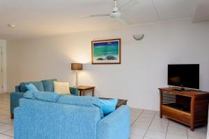 sala de estar con 2 sofás azules y TV de pantalla plana en Baden 74 Rainbow Shores en Rainbow Beach