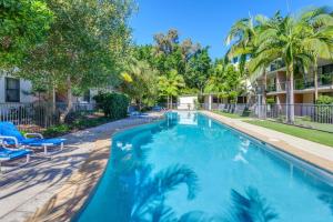 una gran piscina en un patio con palmeras en Baden 74 Rainbow Shores en Rainbow Beach