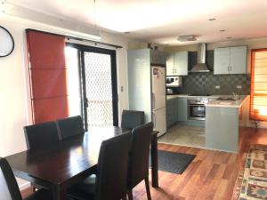 a kitchen and dining room with a table and chairs at 11 Manooka Drive Rainbow Beach in Rainbow Beach