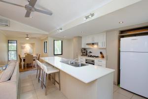 a kitchen with a white refrigerator and a counter top at 6 Orania Court Rainbow Shores in Rainbow Beach