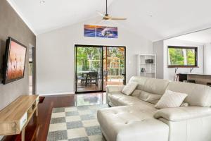 a living room with a couch and a table at 11 Naiad Court Rainbow Shores in Rainbow Beach