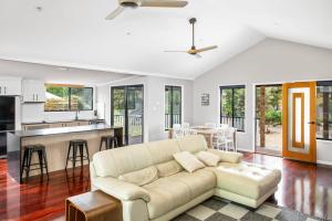 a living room with a couch and a kitchen at 11 Naiad Court Rainbow Shores in Rainbow Beach