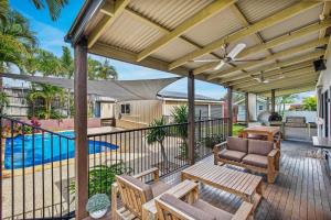 an outdoor patio with a ceiling fan and a pool at 12 Tingira Close Rainbow Beach in Rainbow Beach