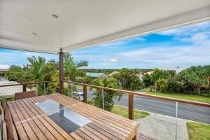 a balcony with a wooden table and a view of the ocean at 12 Tingira Close Rainbow Beach in Rainbow Beach