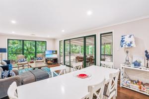 a living room with a white table and chairs at 7 Belle Court Rainbow Shores Fully ducted aircon. Pets welcome in Rainbow Beach
