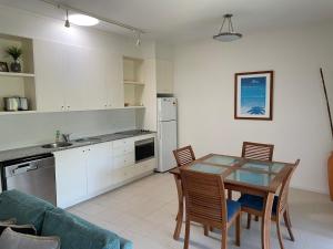 a kitchen and dining room with a table and chairs at Baden 52 Rainbow Shores in Rainbow Beach