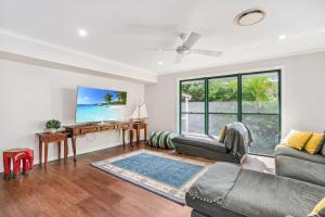 a living room with a couch and a table at 7 Belle Court Rainbow Shores Fully ducted aircon. Pets welcome in Rainbow Beach