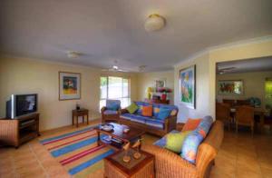 a living room with two couches and a television at 4 Boronia Place Rainbow Beach in Rainbow Beach